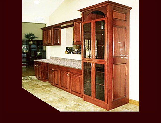 Custom Stained Mahogany Bar Cabinetry. Raised Panel door style. Full height media center with black glass. Decorative end panels. Crown Moulding.